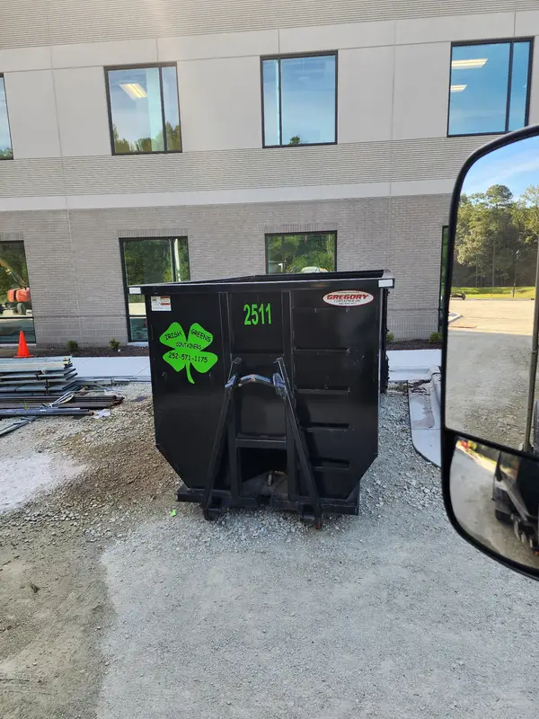 Irish Greens container 2511 on gravel outside a new commercial building